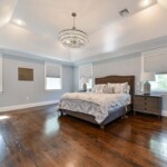 Custom hardwood floors rise to meet the elegant vaulted ceiling.