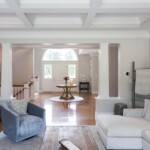 Living room includes a custom-designed coiffured ceiling with a view of the main entry.